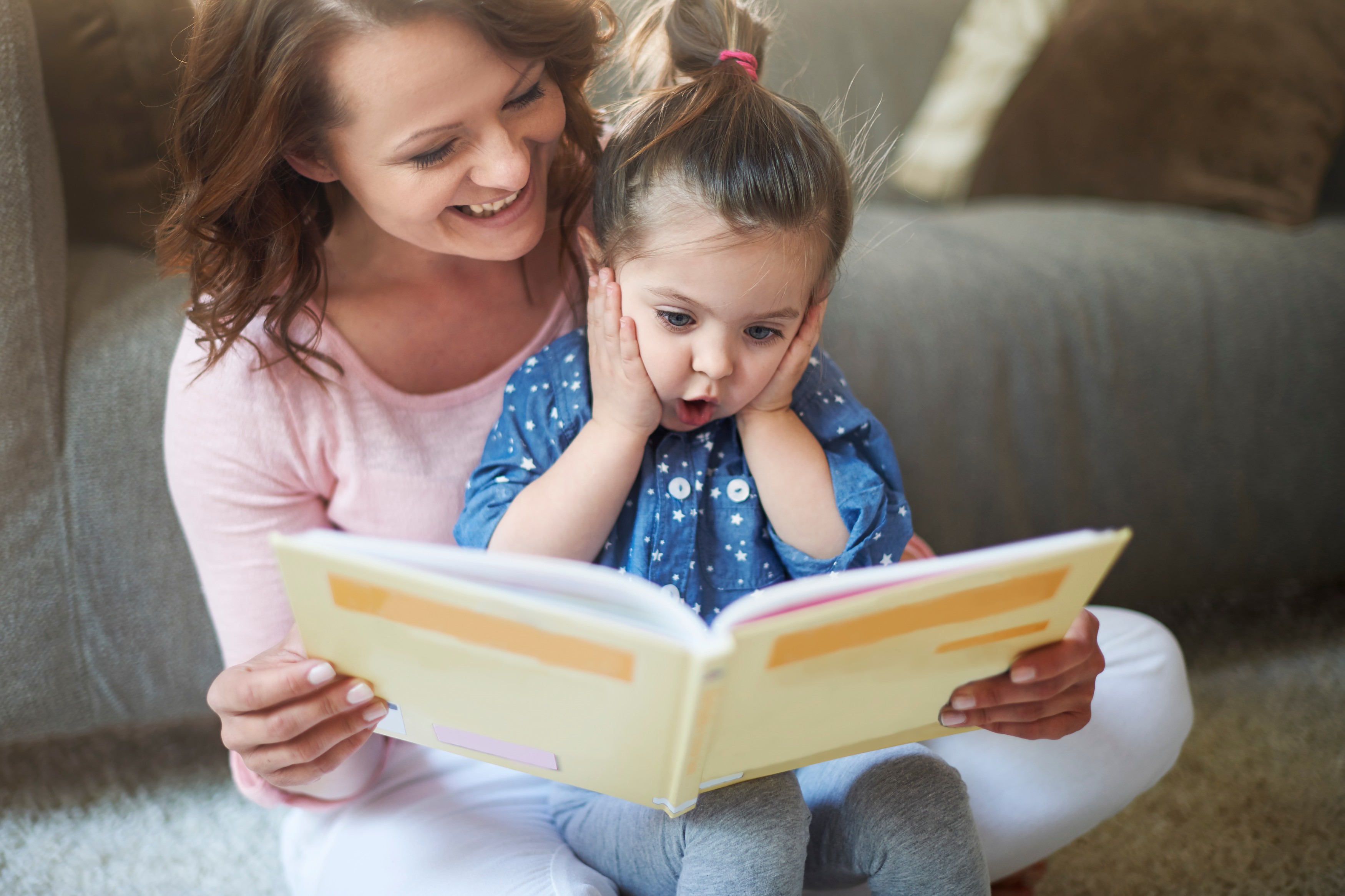 Teacher reading a storybook to a circle of attentive children